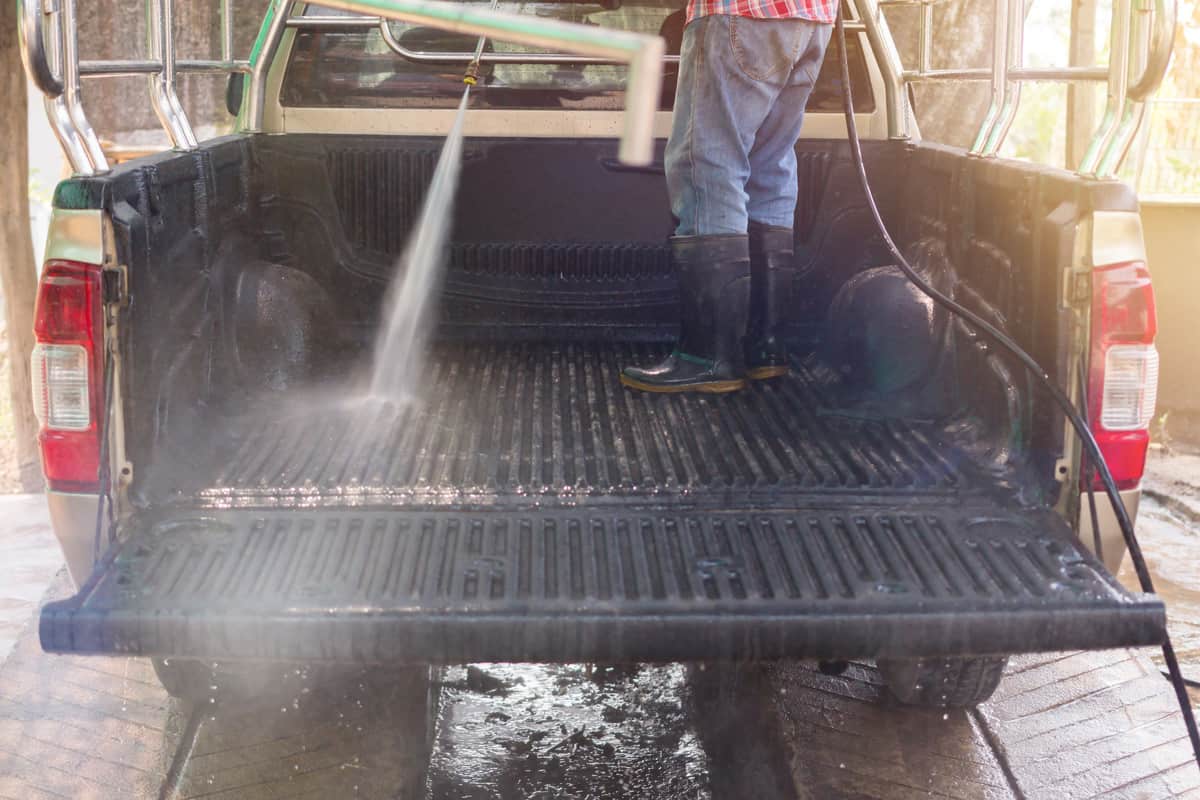 Car wash workers are using high-pressure water washers for washing cars.