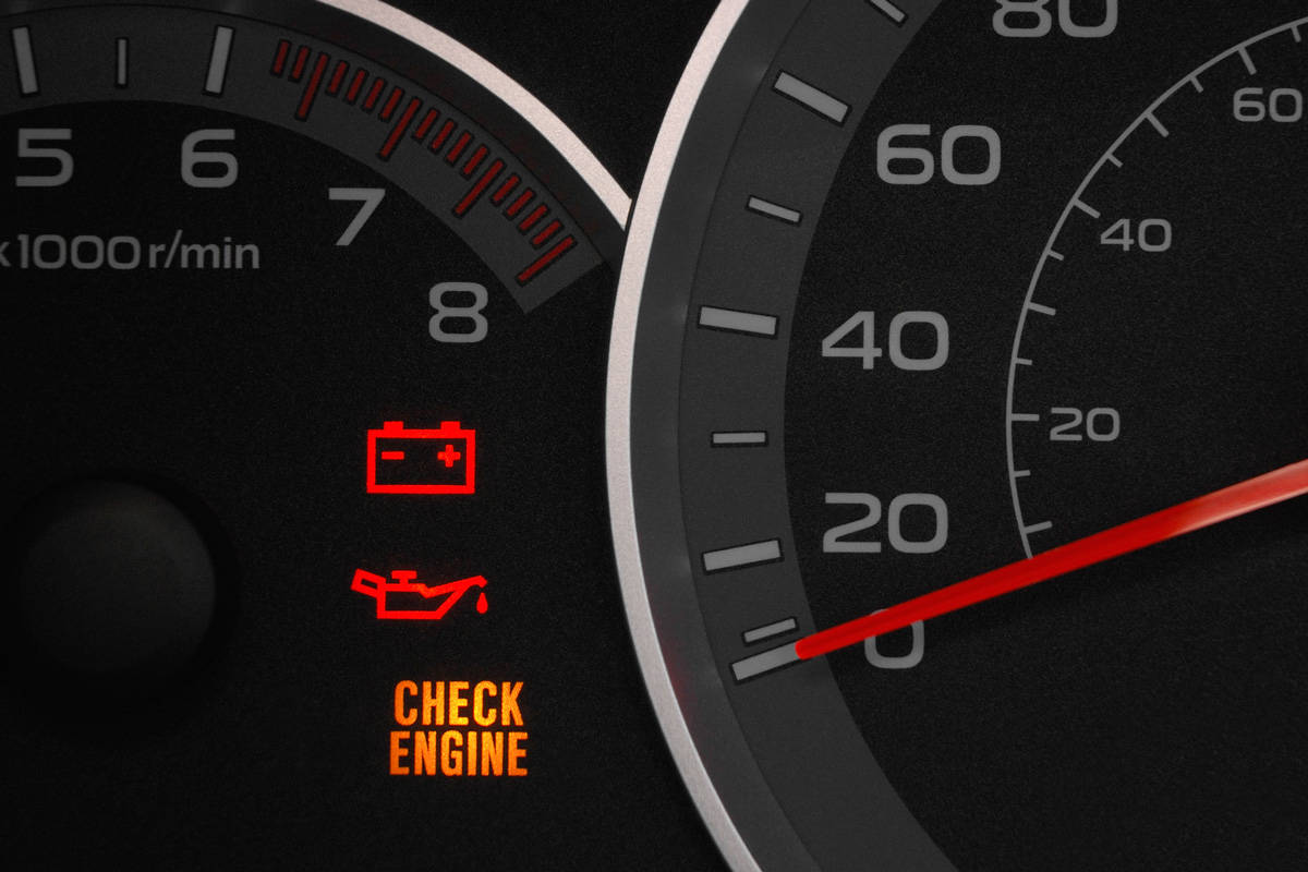 Close up on a cluster with the check engine warning light on indicating a car failure.