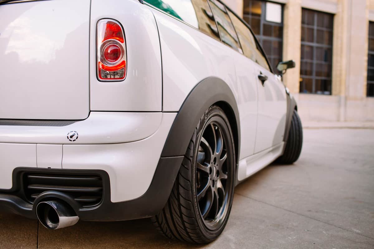  Detail of Mini Cooper Clubman S small station wagon. Rear end of the car parked on the street. Featuring "bar doors", JCW exhaust and low profile tires..
