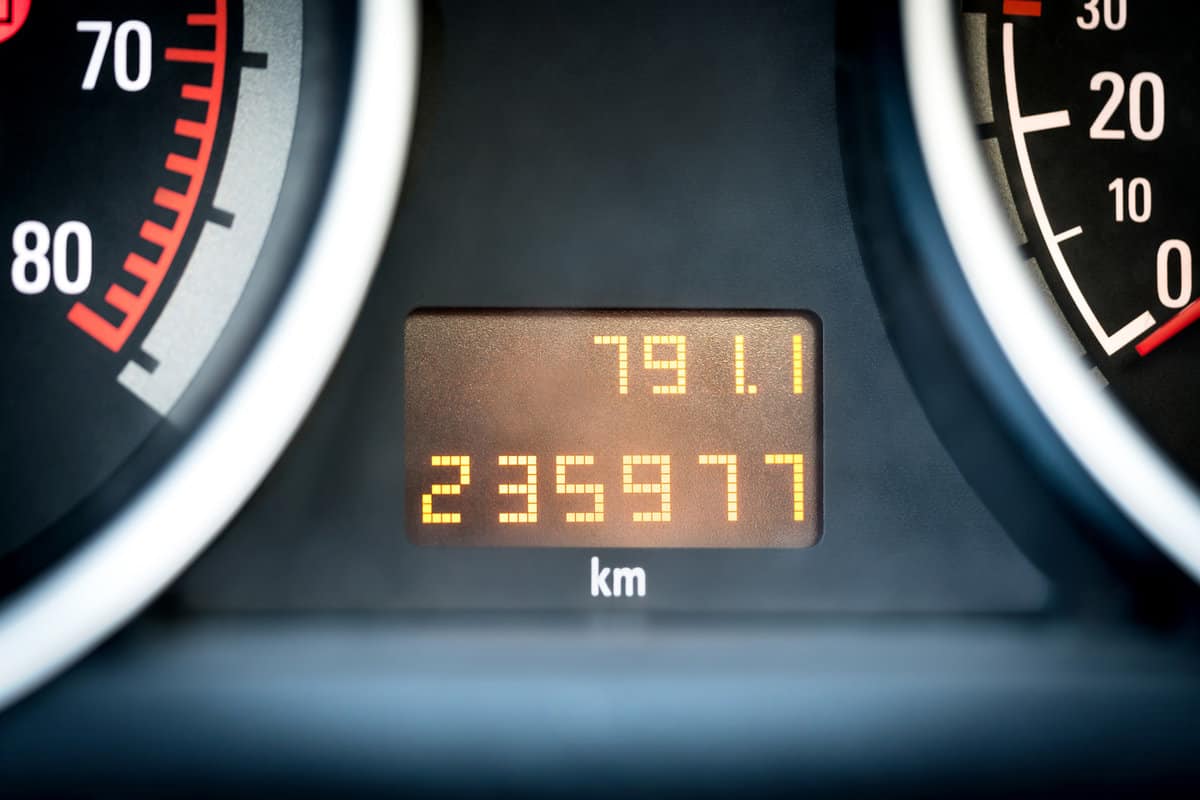 Digital car odometer in dashboard. Used vehicle with mileage meter. Numbers in kilometers.