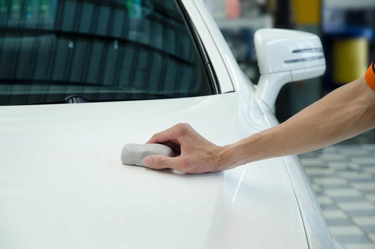 Hand polishing by clay bar and clay lubricant for remove dirt on car surface