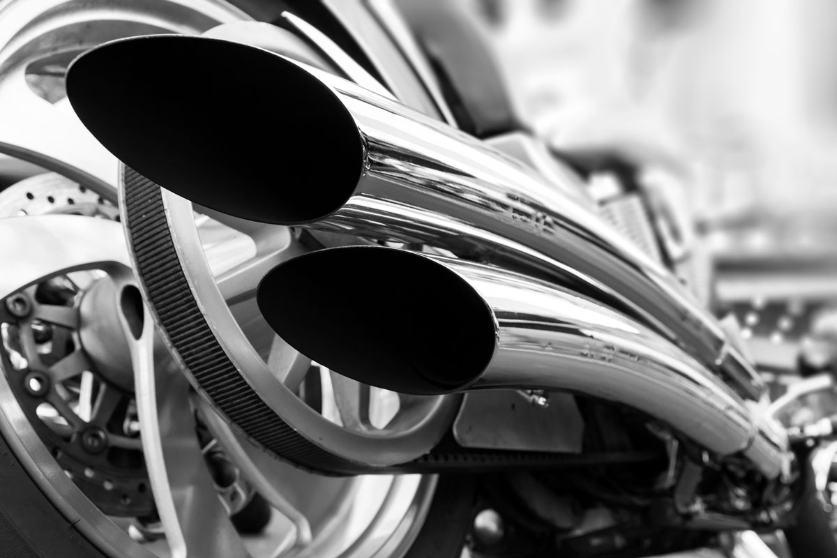 Low angle black and white photograph of motorcycle with double exhaust