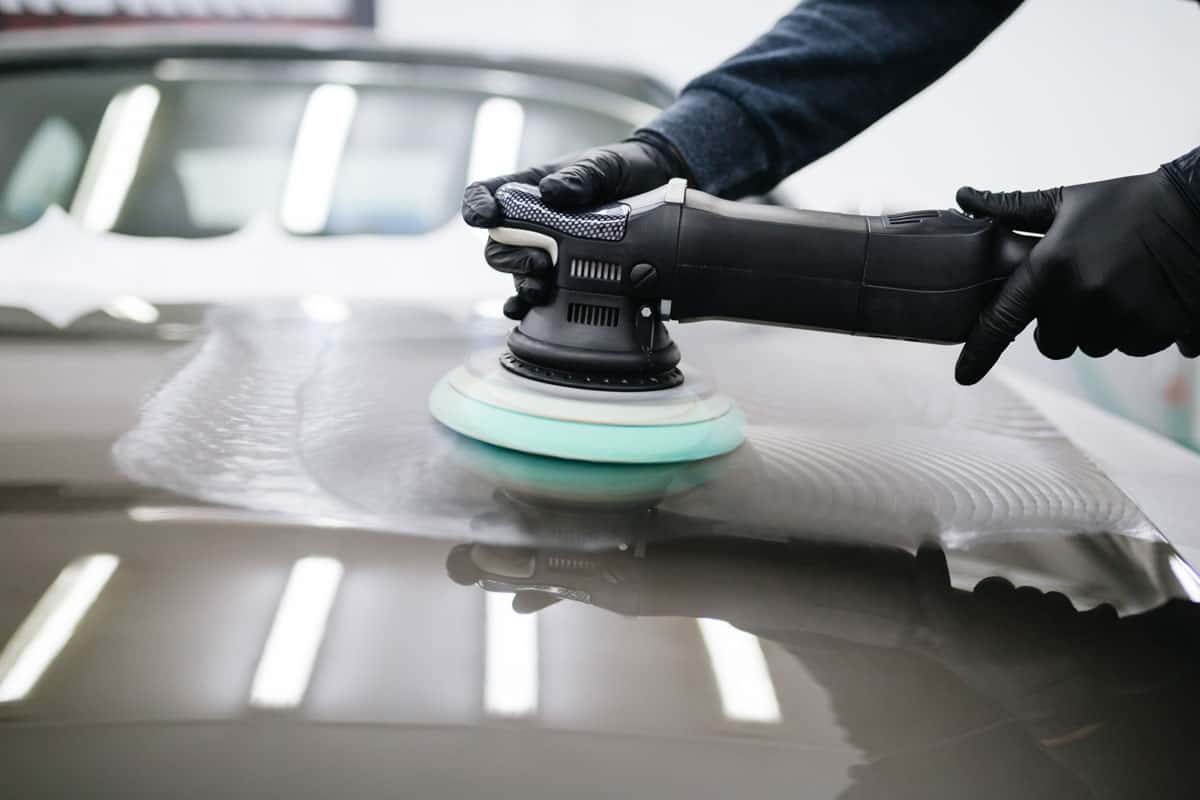 Man polishing the car hood with new paint