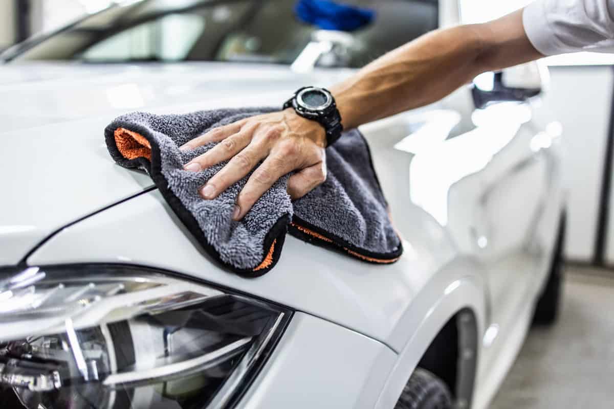 Man wiping his car clean with a wiping cloth
