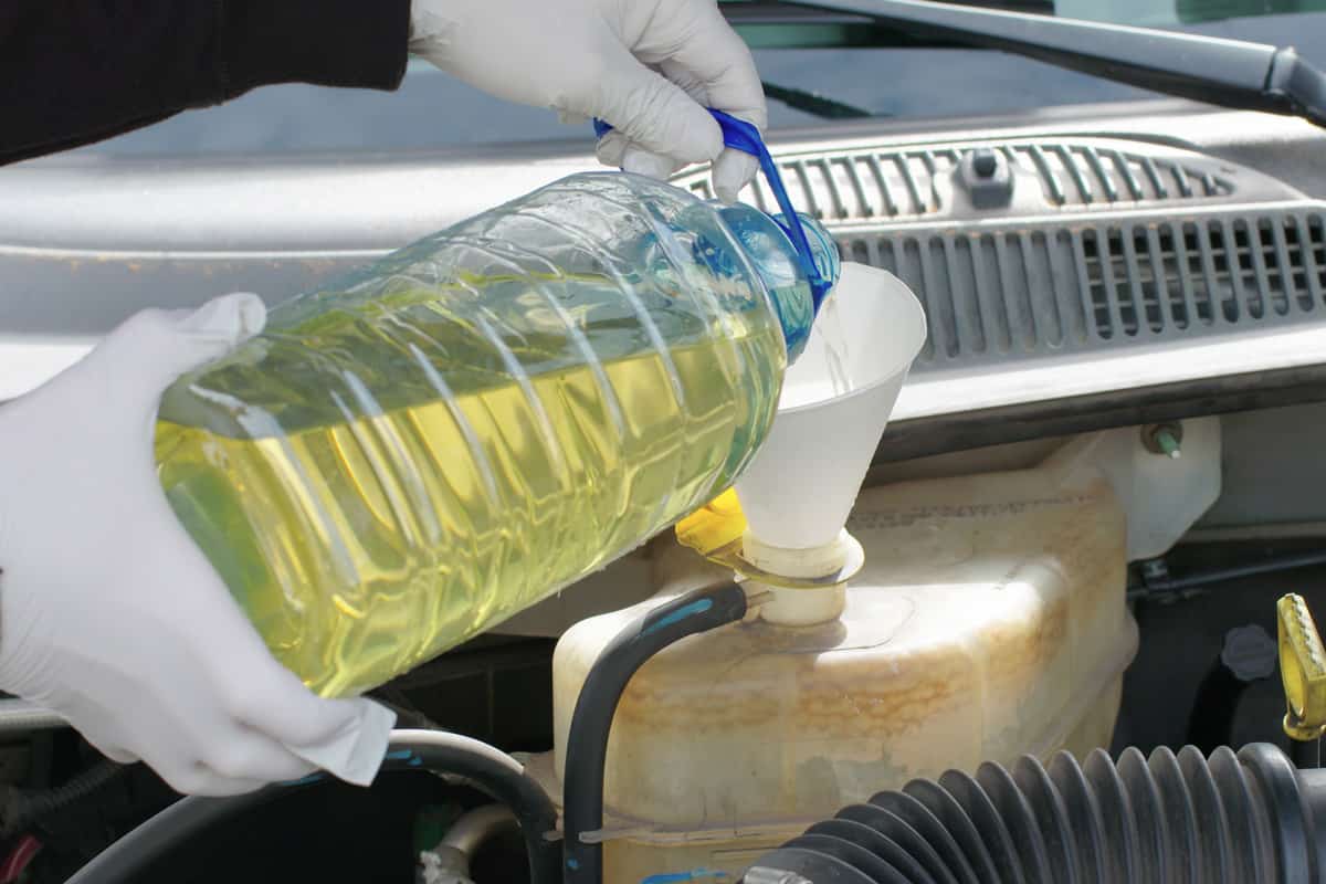 Mechanic or Driver Adding Coolant With Antifreeze Additive To Car or Truck Engine. 