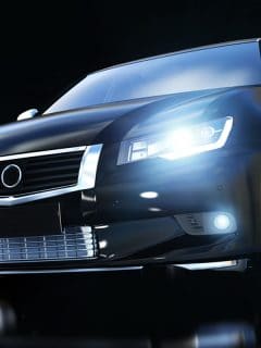 Modern black metallic sedan car in spotlight, Car Lights Dimming When Braking - What To Do?