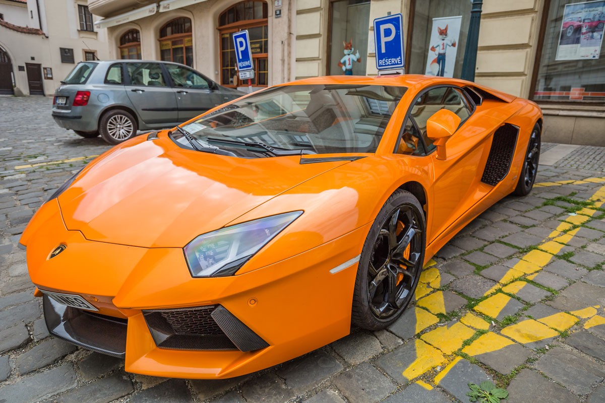 Orange Lamborgini is parked on a cobblestone street in historical center in Brno, Czech Republic