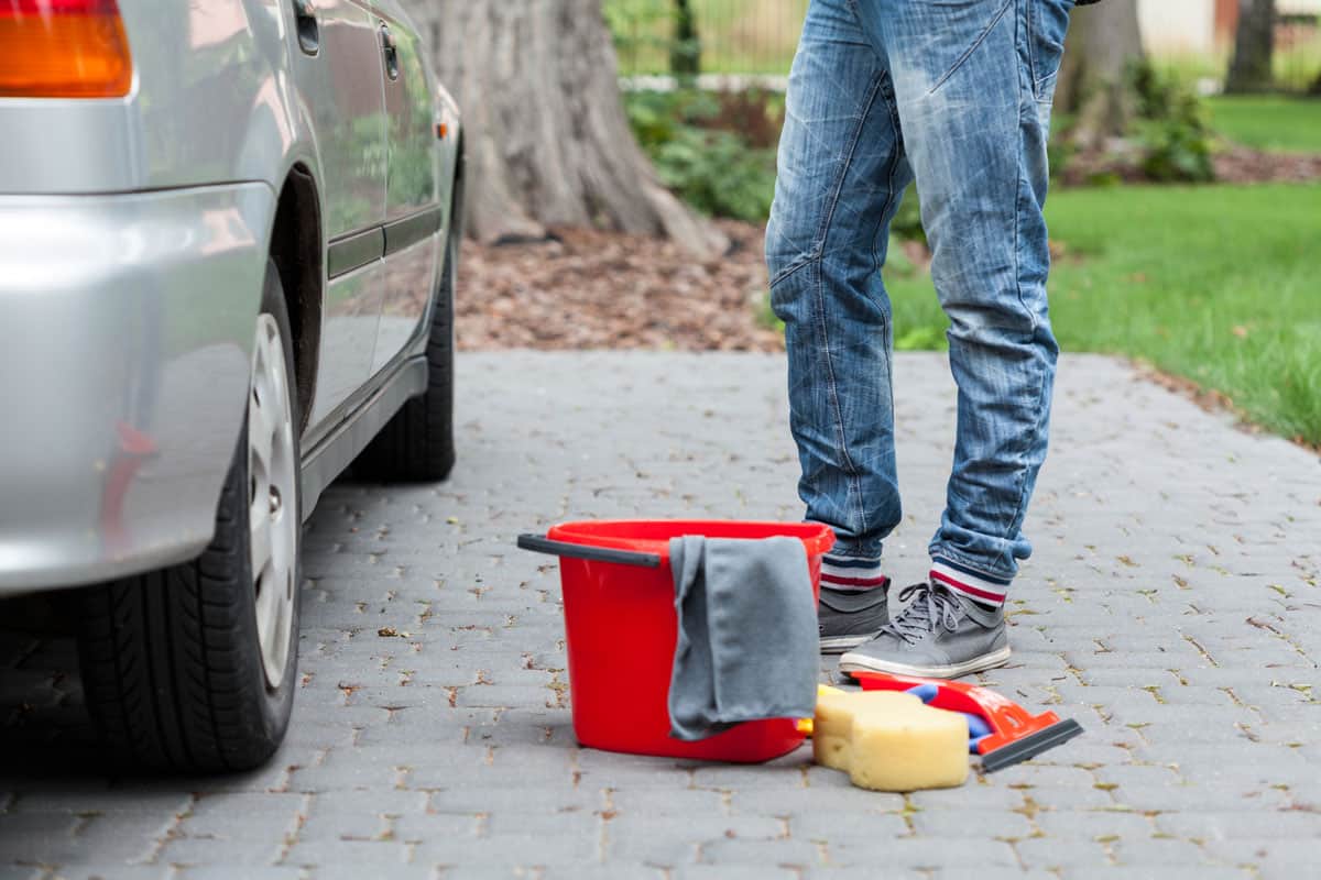 Red bucket, sponge and remain tools for cleaning the car