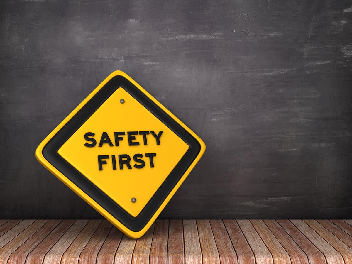 SAFETY FIRST road sign on chalkboard background