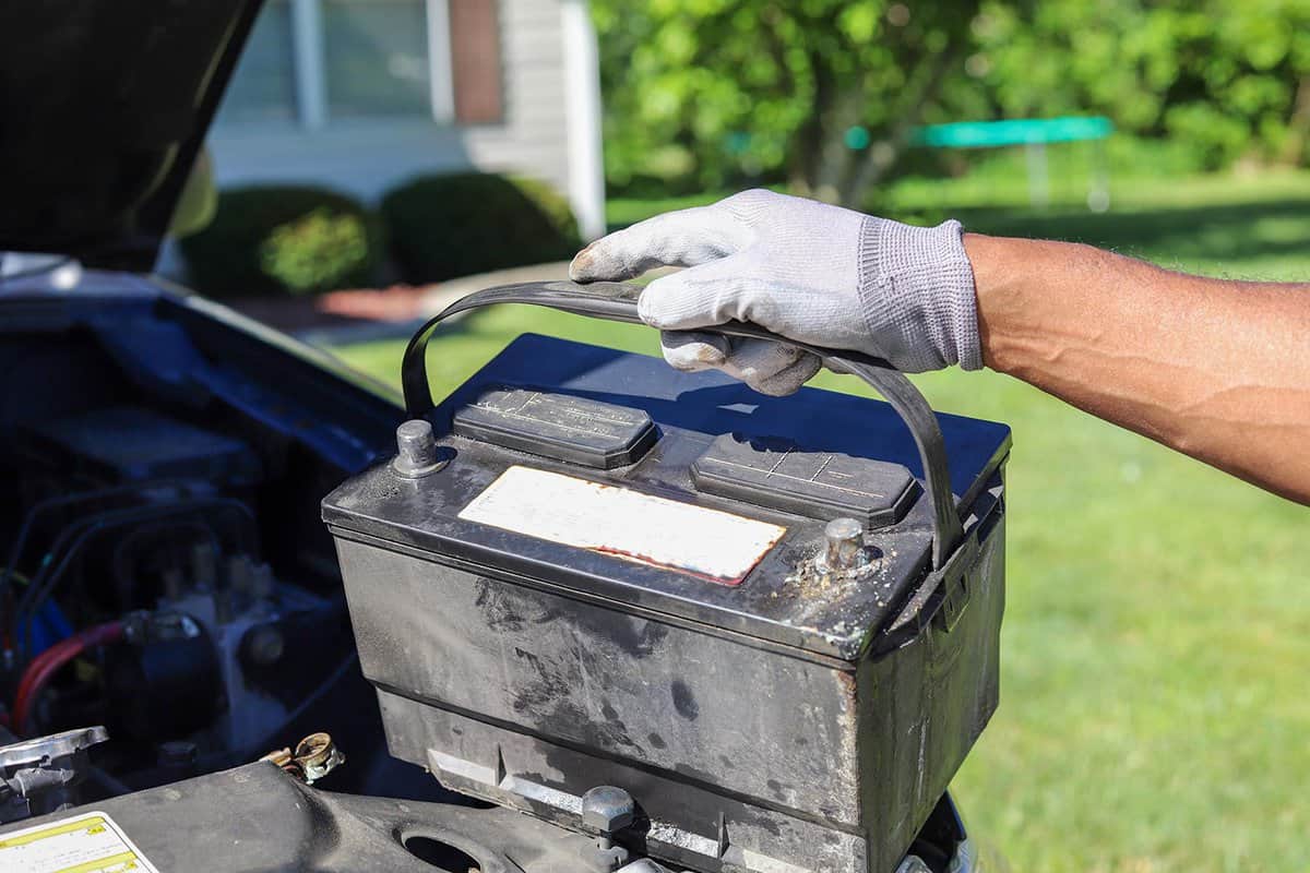 Taking a car battery out of a truck
