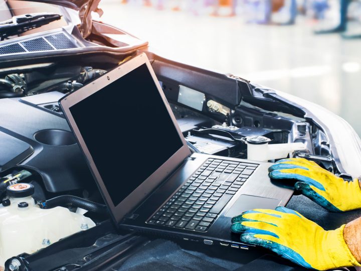 Technician tuning engine car with the computer laptop in repair garage, Ktuner Vs Hondata: Which Is Better?
