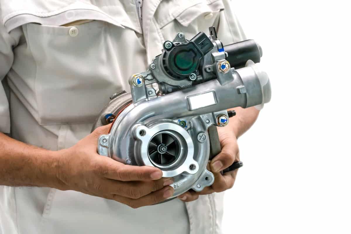 Turbocharged intelligent car variants in the hands of a car mechanic on a white background.