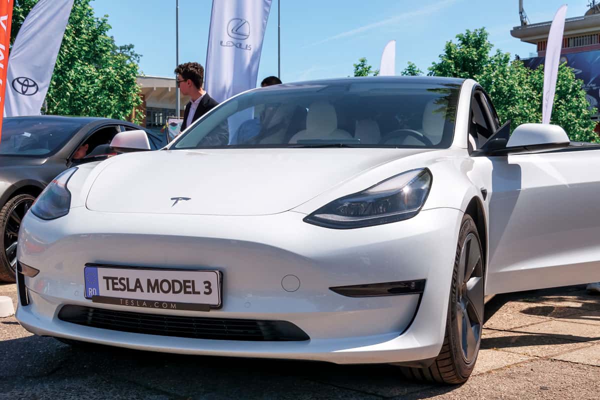 White Tesla Model 3 at a small car show