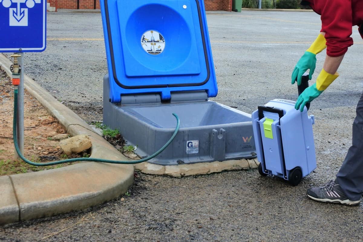 Woman dumping a toilet tank in a dumping point