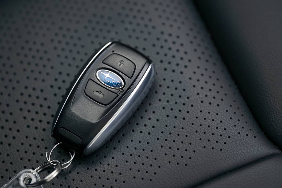 a Subaru Car Key With Buttons, on a Leather Background