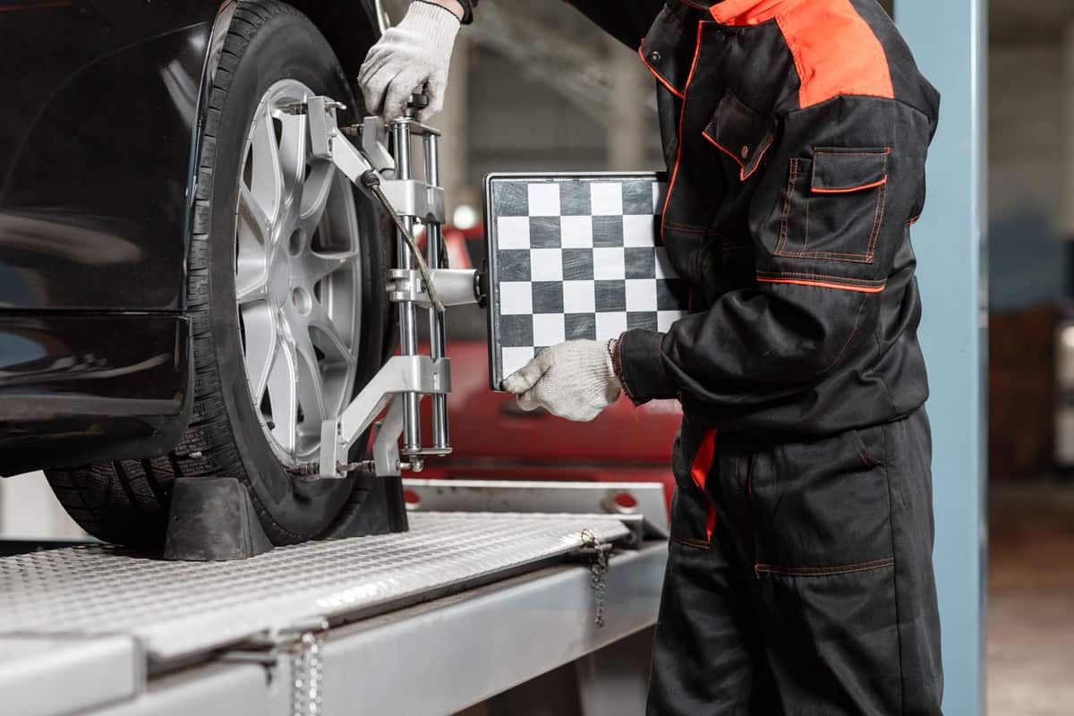 auto mechanic sets the car for diagnostics and configuration. Wheel alignment equipment on a car wheel in a repair station.