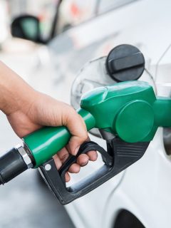 man refueling a white car while holding the fuel nozzle, Can You Mix Ethanol And Non-Ethanol Gas?