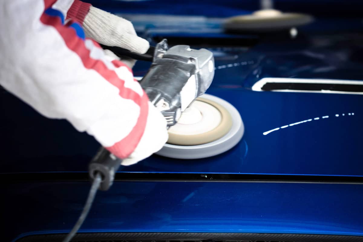 polishing the hood with wax of a race car