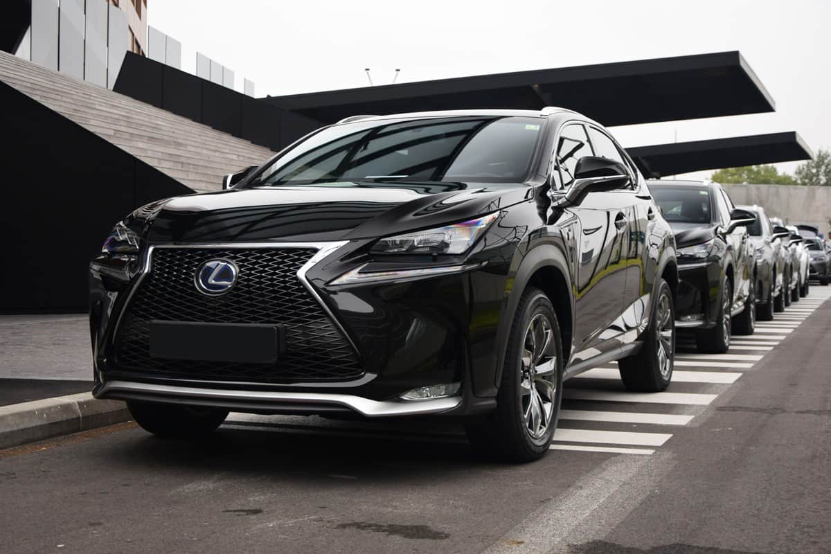 A black Lexus UX parked in front of a building
