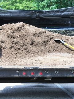 A dump trailer carrying dirt, Does My Truck Charge My Dump Trailer Battery?