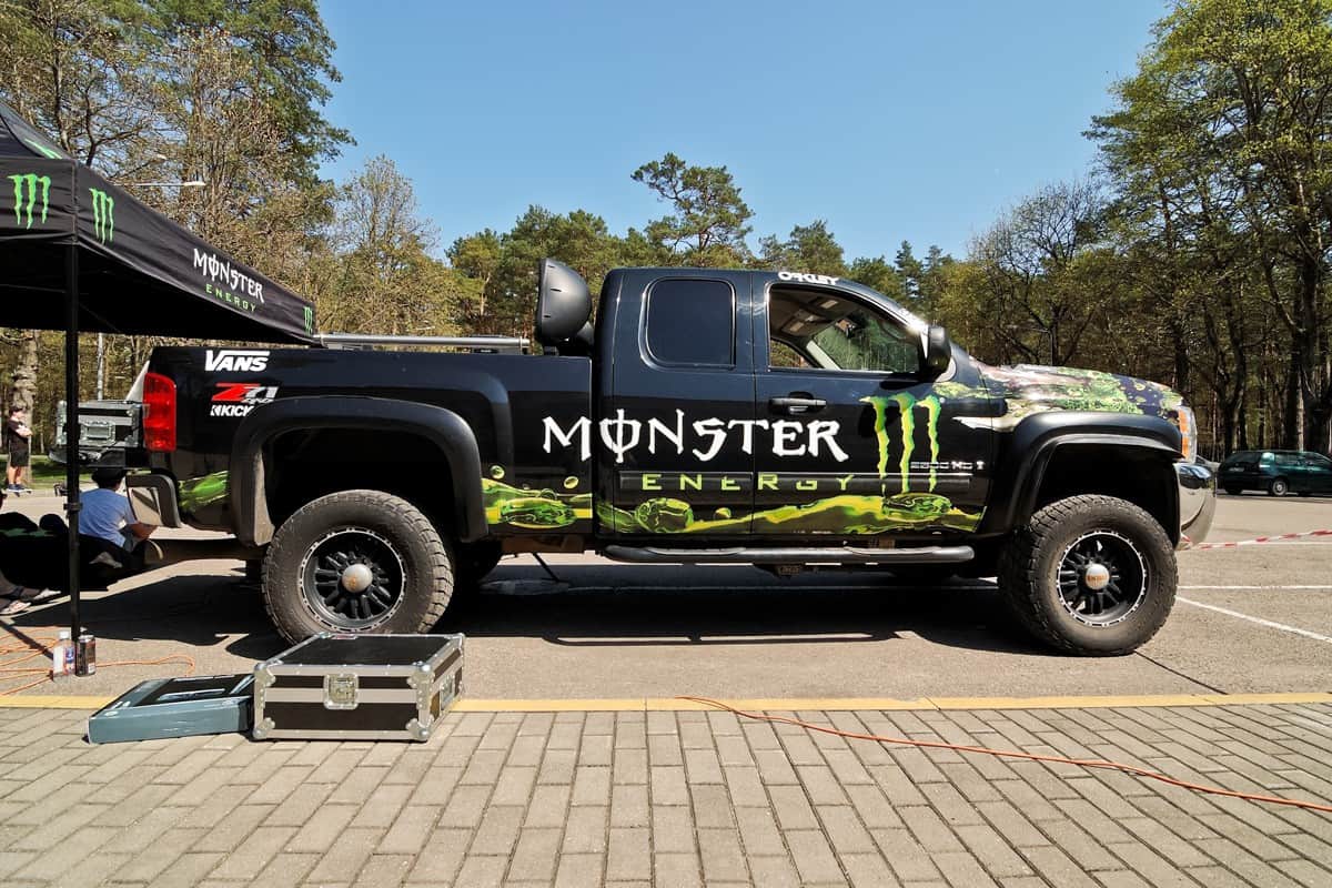 A huge black Chevrolet Silverado at a monster truck show