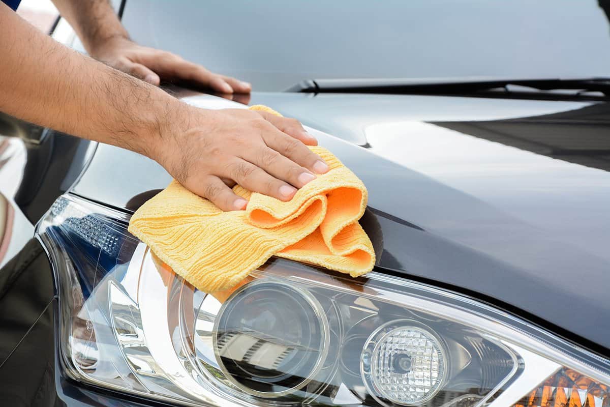 A man cleaning car with microfiber cloth