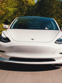 A new Tesla Model 3 all electric vehicle driving down a country road, Tesla Model 3 Burning Smell - Why And What To Do?