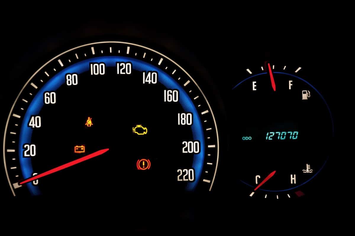 A speedometer showing the check engine, seatbelt lights on