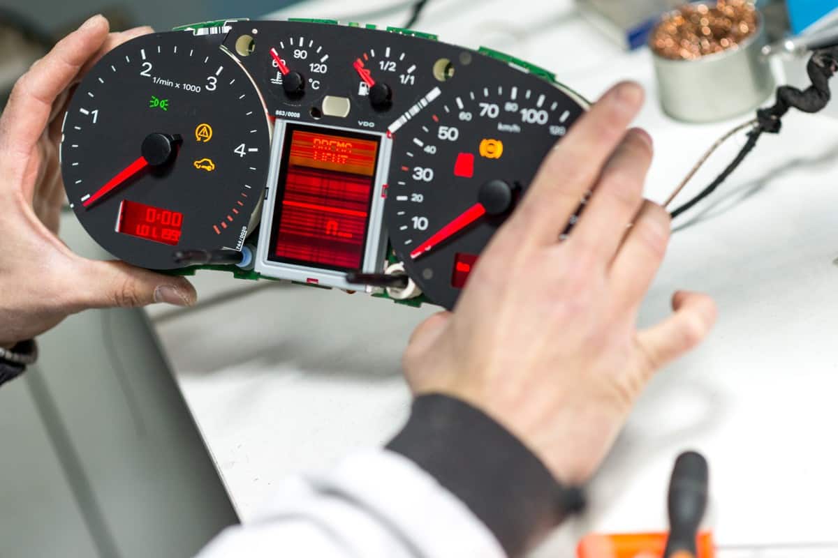 A technician checking and running a diagnosis on the car dashboard