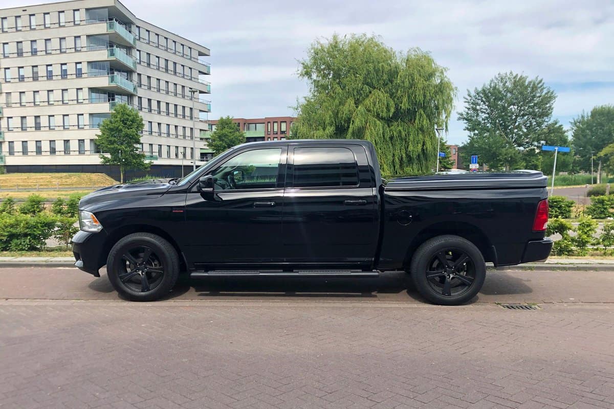 Black Dodge Ram pick up parked on a public parking lot.
