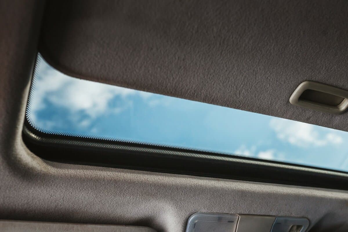 Blue sky through an open car sunroof - view from the passenger compartment — Photo