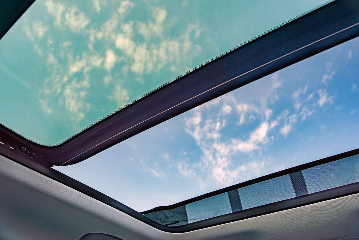 Blue sky through an open car sunroof