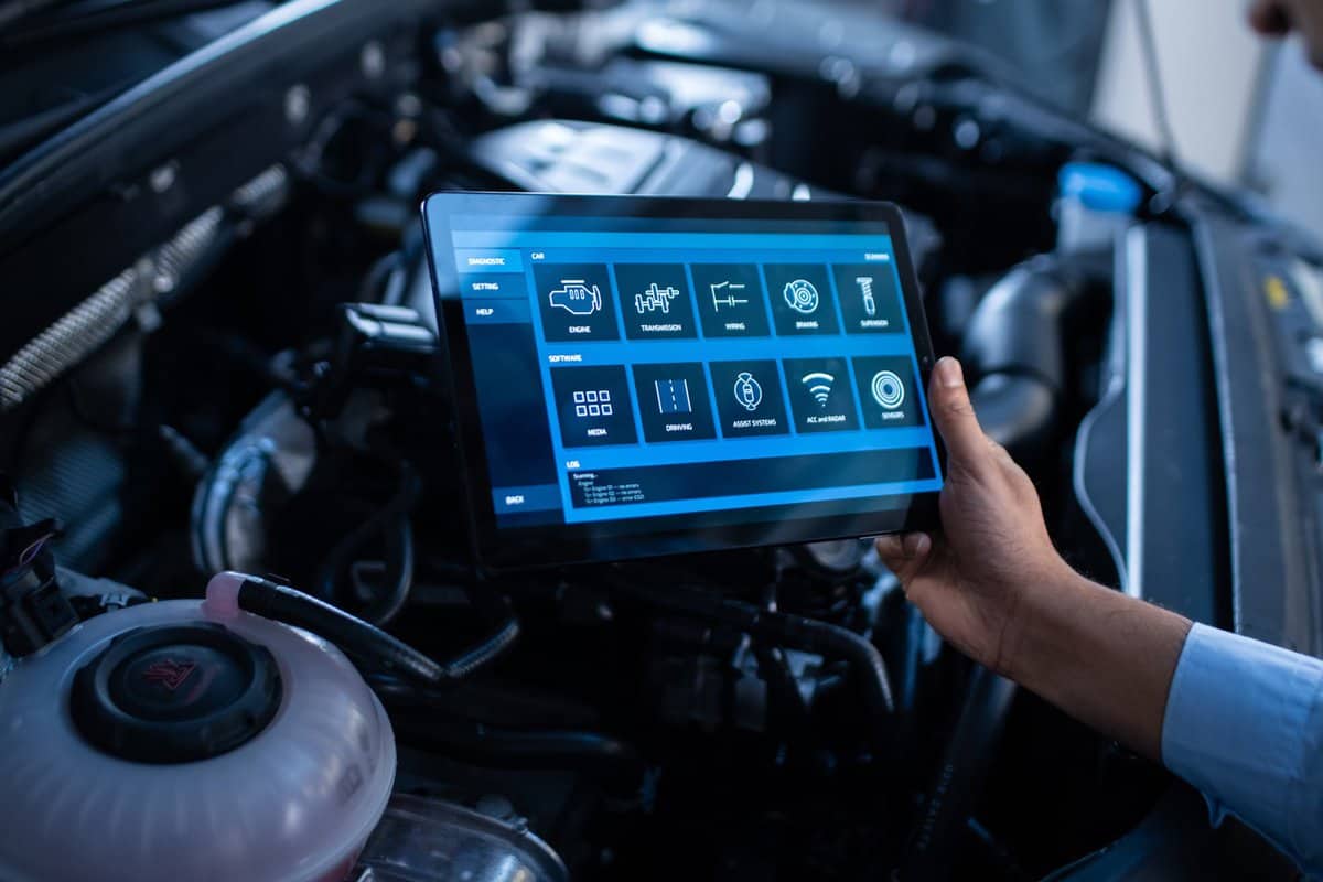 Car Service Manager or Mechanic Uses a Tablet Computer with a Futuristic Interactive Diagnostics Software. Specialist Inspecting the Vehicle in Order to Find Broken Components In the Engine Bay. — Photo