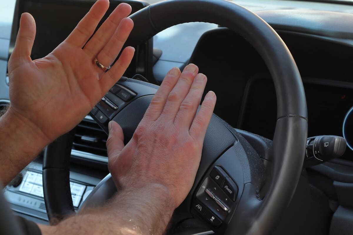 Close up of driver's hands honking horn