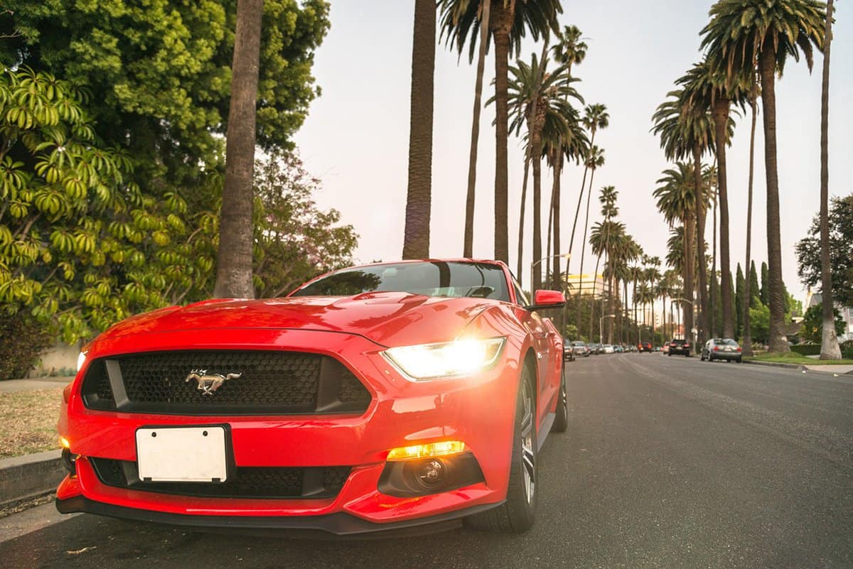 Front view of a red Ford Mustang GT car parked on the street along a street