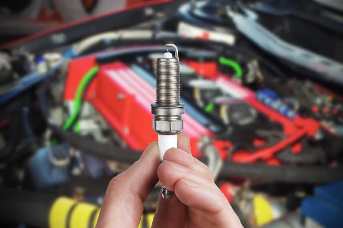 Mechanic holds a spare part spark plug in hand — Photo