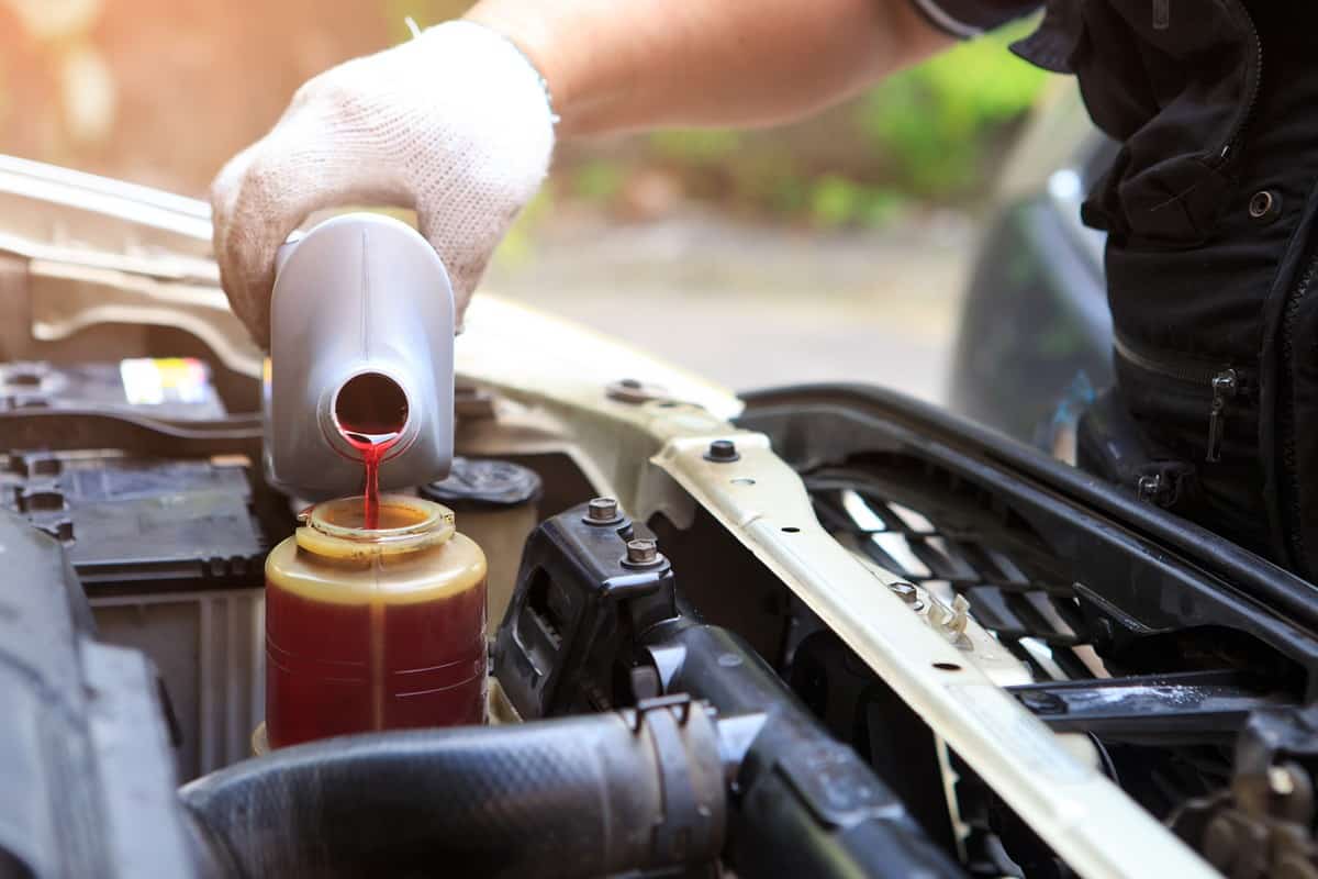 Pouring new transmission fluid into the car