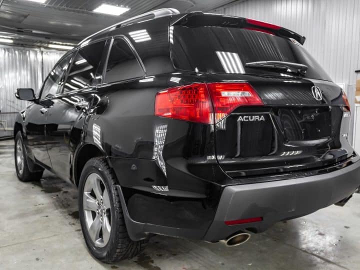 Rear view of used Acura MDX 2008 year black color with red taillamps standing in the light service box of the detailing workshop after polish and washing. - Acura ILX Won't Start And Says Check Brake System - Why And What To Do?