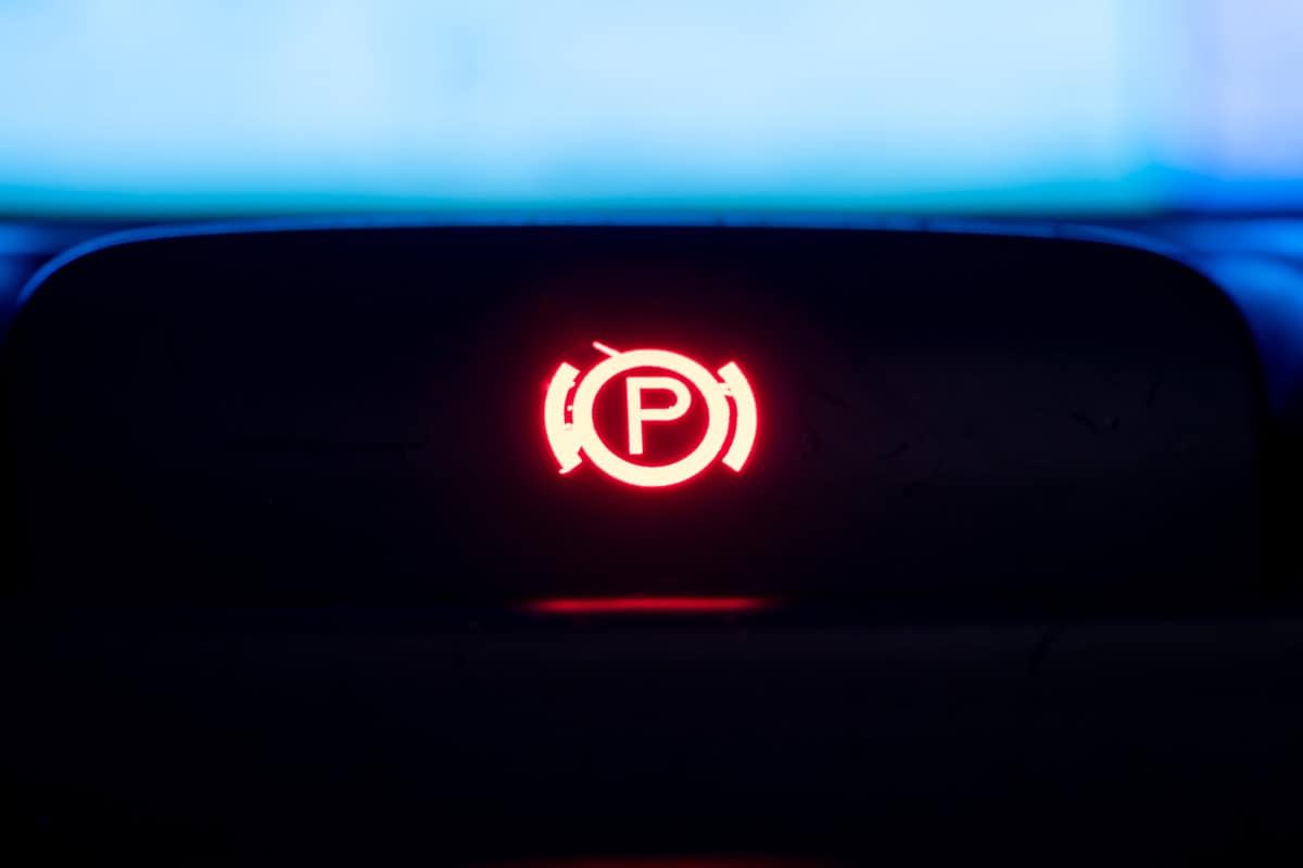 Red illuminated hand brake sign close-up 