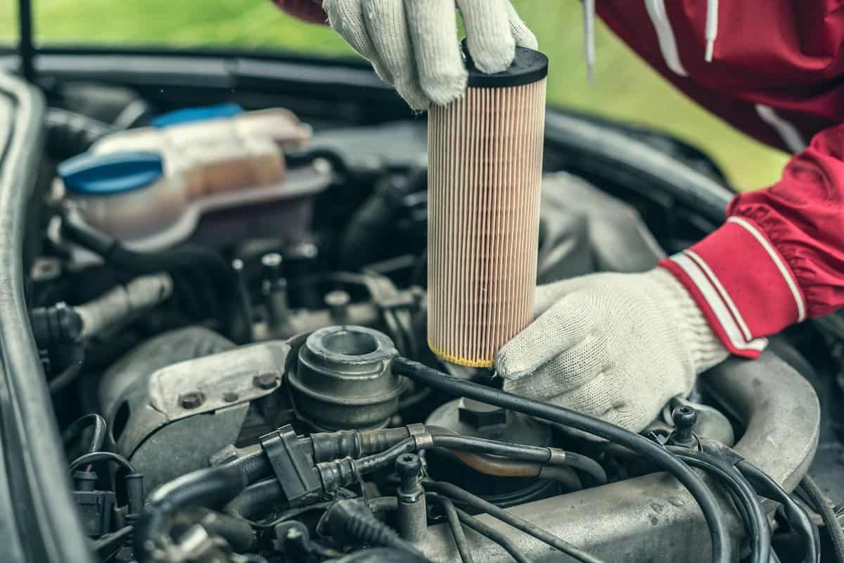 The auto mechanic replaces the car's oil filter