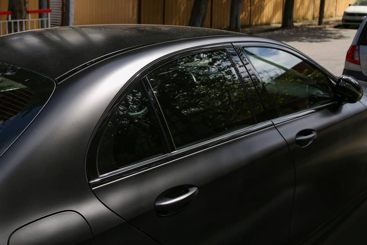 The car is covered with black vinyl, matte finish, anti-scratch and dustproof. — Photo