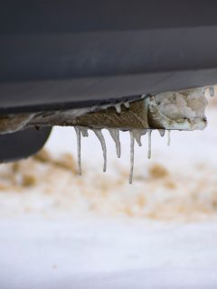 The exhaust pipe of the car is clogged with ice. The frozen exhaust pipe of a car standing in the snow. Close-up. - Exhaust Pipe Clogged With Ice - What To Do