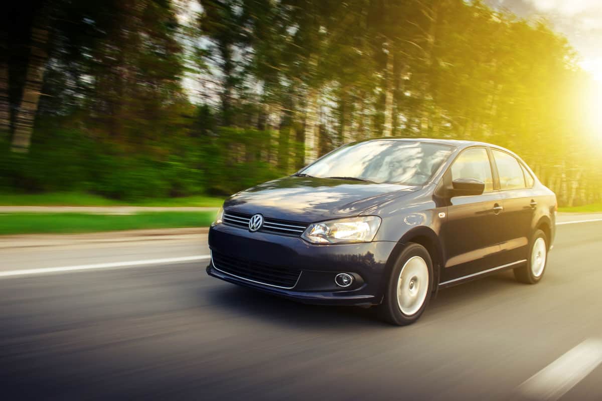 Volkswagen Polo Sedan car drive on the road at sunset