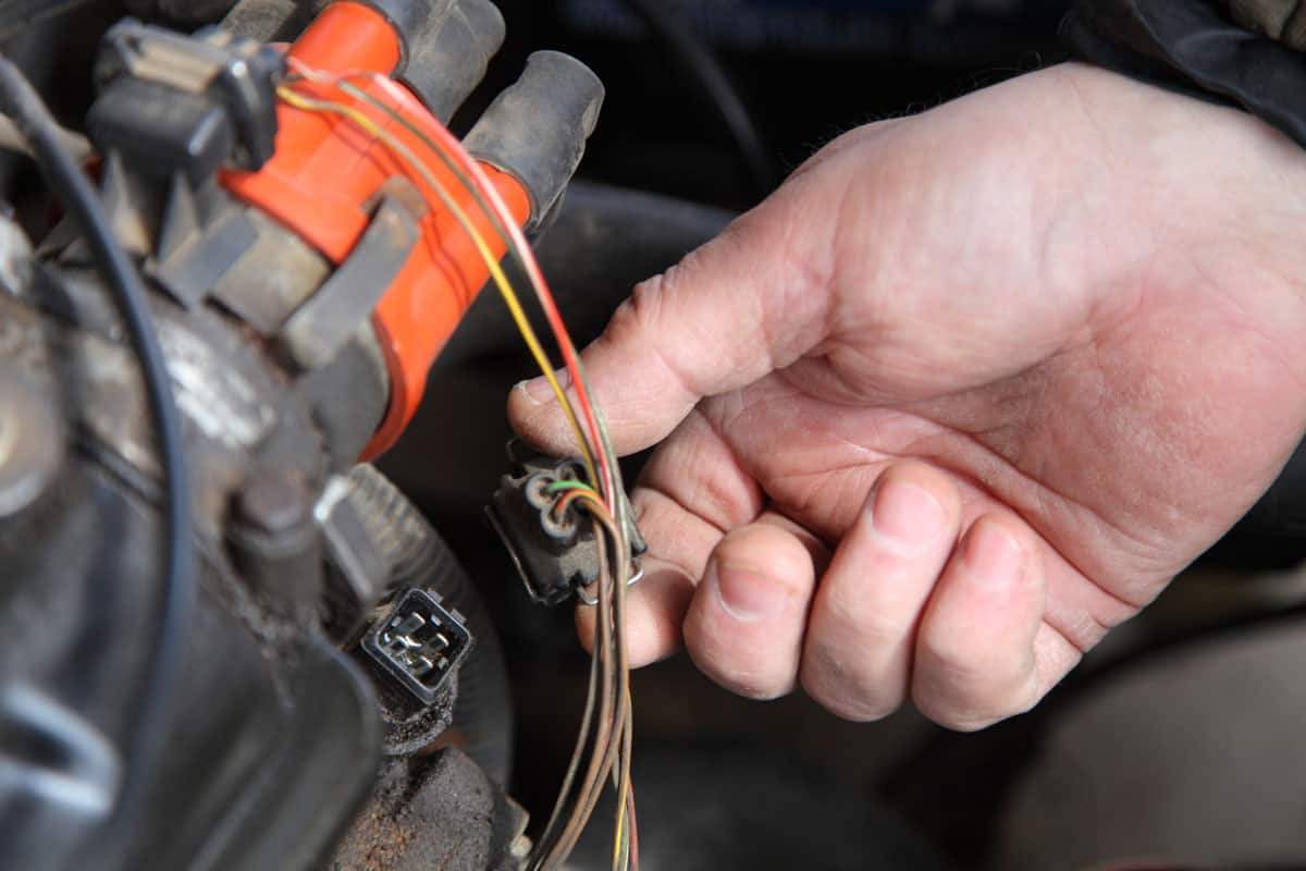 photo of a man mechanic holding replacing ambient temperature for car