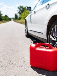 A car parked on the side of the road, an empty red canister. Selective focus, noise. The driver is on the road. Help on the road. Fuel shortage - oil, diesel, gasoline, petrol. - How To Put Gas In A Car Without Funnel