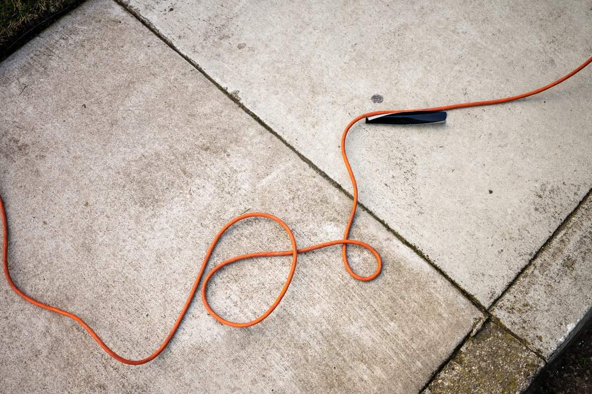An extension cord is strewn across a walkway creating a trip hazard.