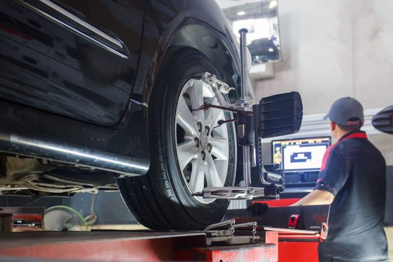 Car on stand with sensors on wheels for wheels alignment camber check in workshop of Service station, Car Still Pulls After Alignment - Why And What To Do?