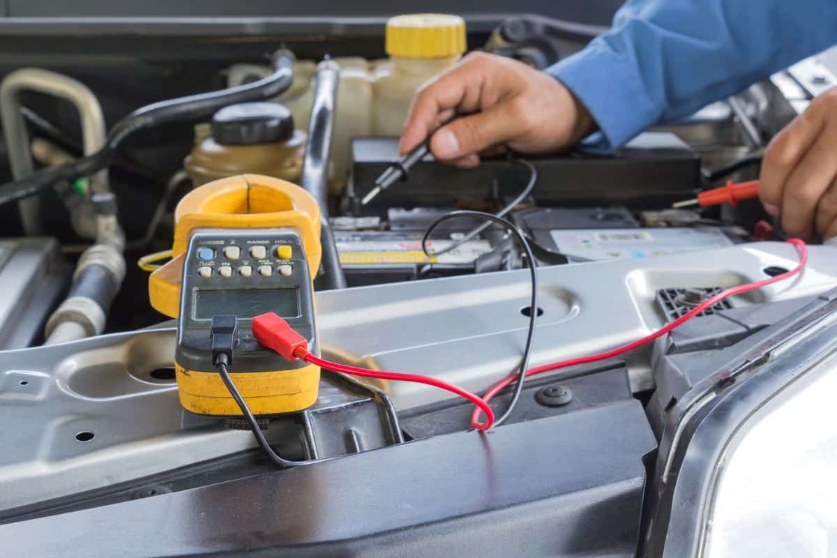 Car repair service, Auto mechanic checking a car battery level by voltmeter