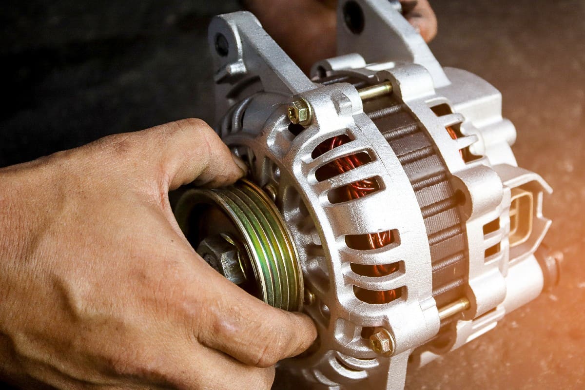 Change new car alternator with hand in the garage or auto repair service center