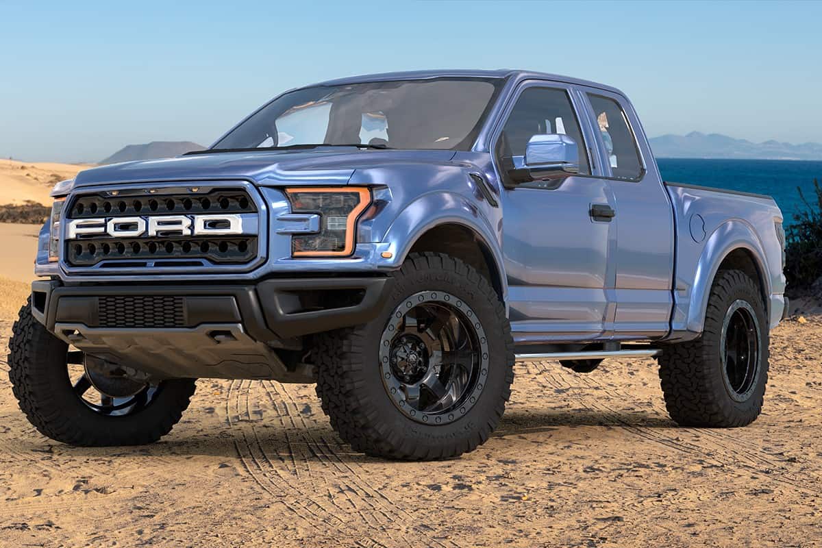A Ford F-150 Raptor standing on a sand dune